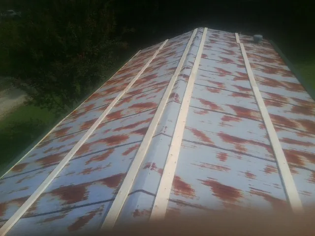Rusted metal roof panels with new wood purlins before replacement — Storm Damage Roof Repair in Holton by Roofing Brothers